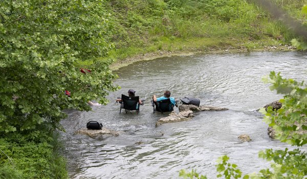 People relaxing with chair in the water at Palmetto State Park