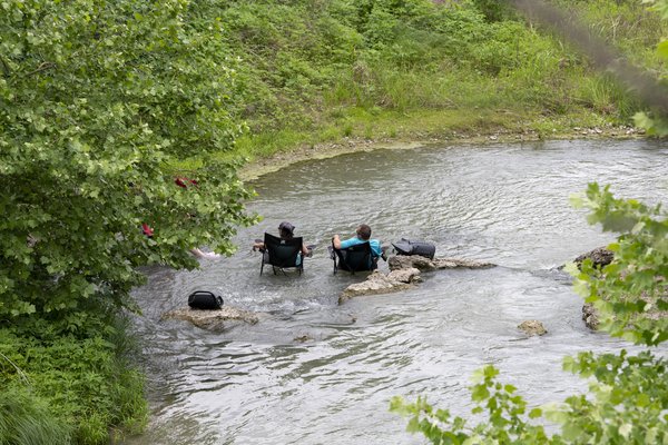 People relaxing with chair in the water at Palmetto State Park