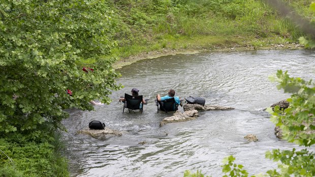People relaxing with chair in the water at Palmetto State Park