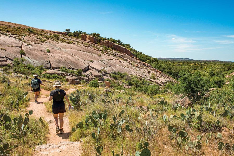People hiking on a trail to Enchanted Rock.