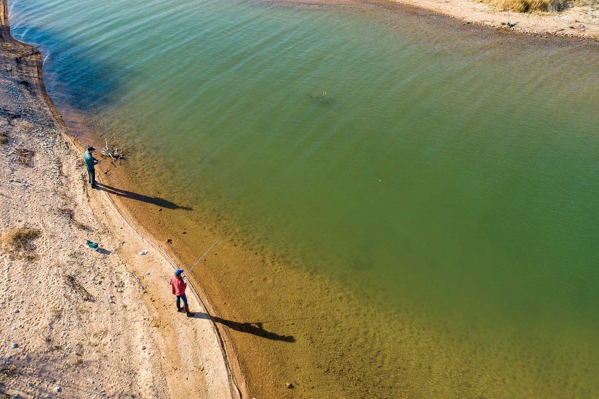 People standing on the bank of a river.