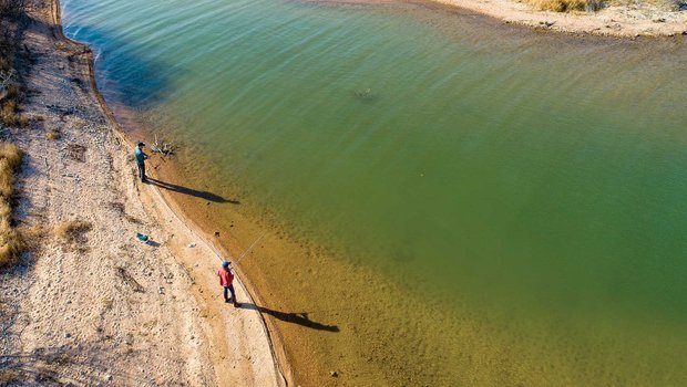 People standing on the bank of a river.