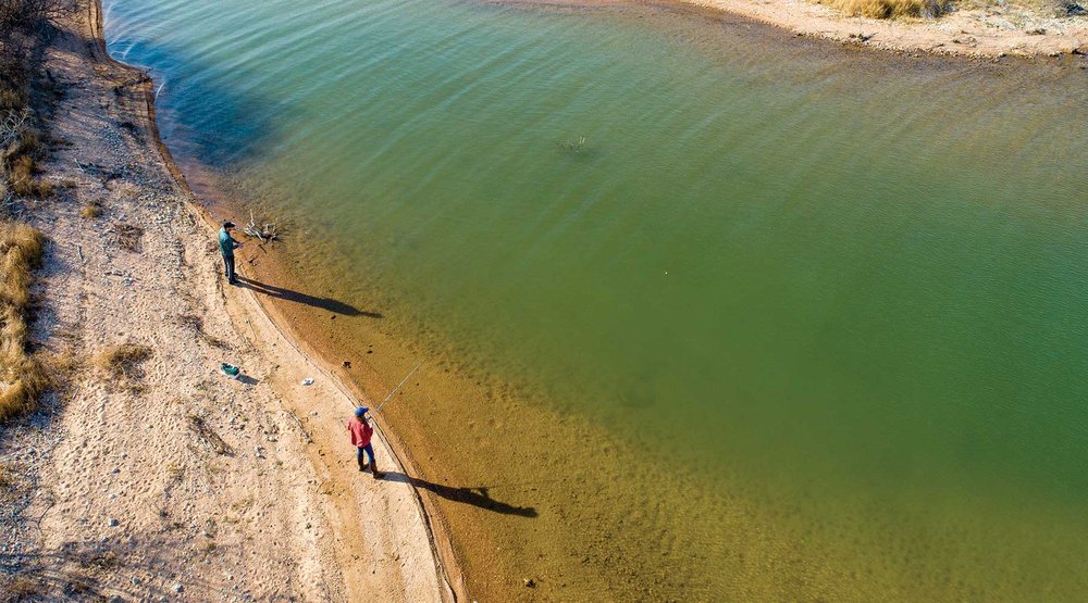People standing on the bank of a river.