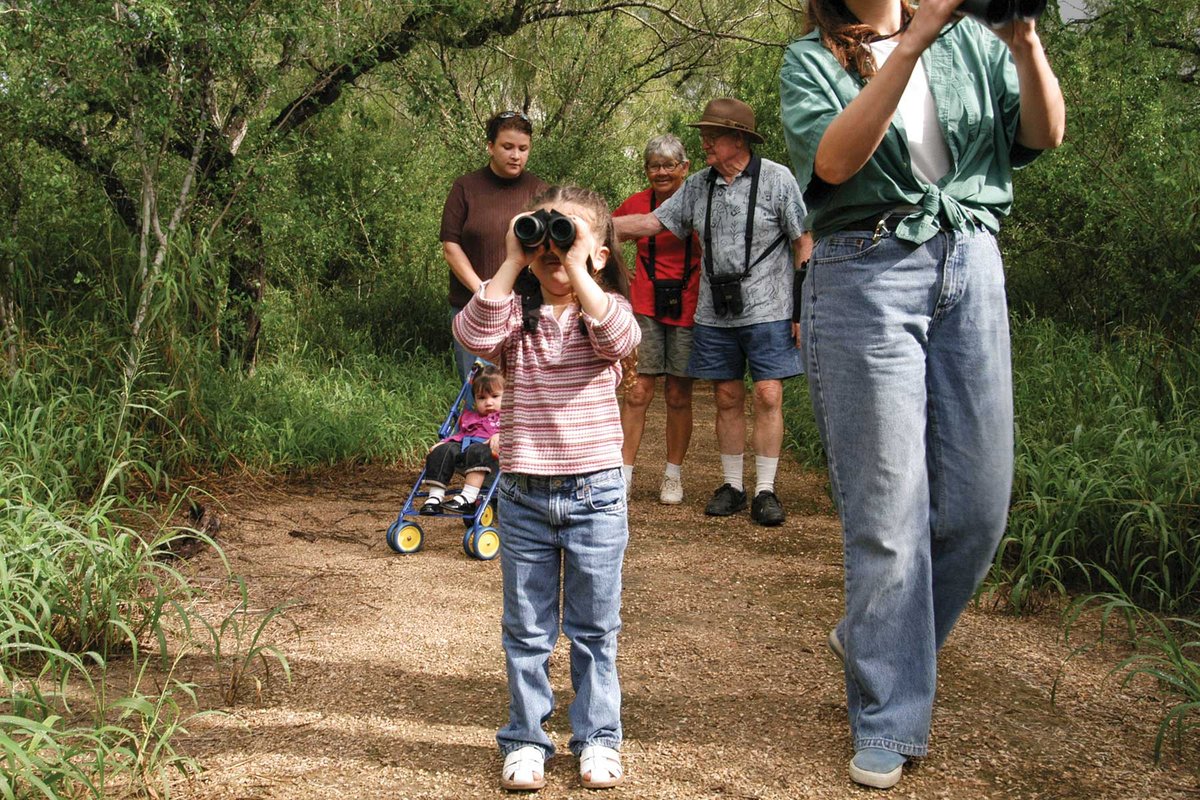 People walking down a wildlife trail in the woods.