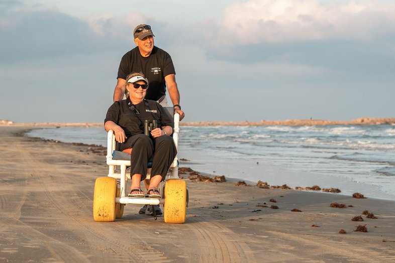 Person being pushed in a beach wheelchair.