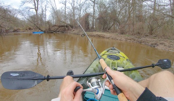 Person in a kayak casting their rod.