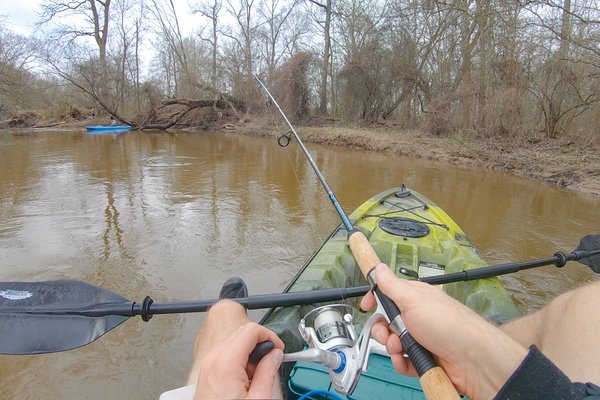Person in a kayak casting their rod.