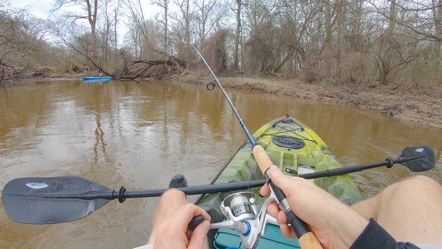 Person in a kayak casting their rod.