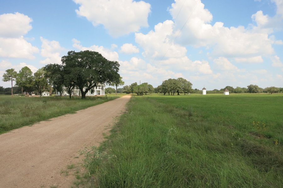 A dirt road going towards a house in Provident City