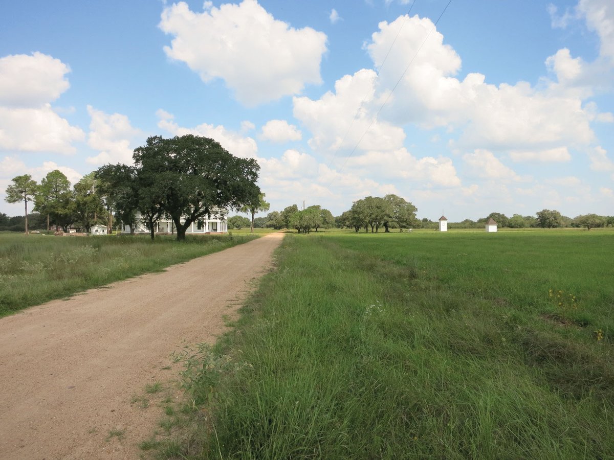 A dirt road going towards a house in Provident City