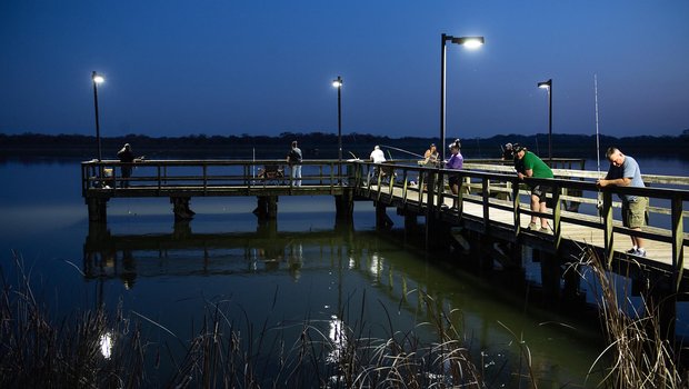 Purtis Creek pier lit up with people night fishing