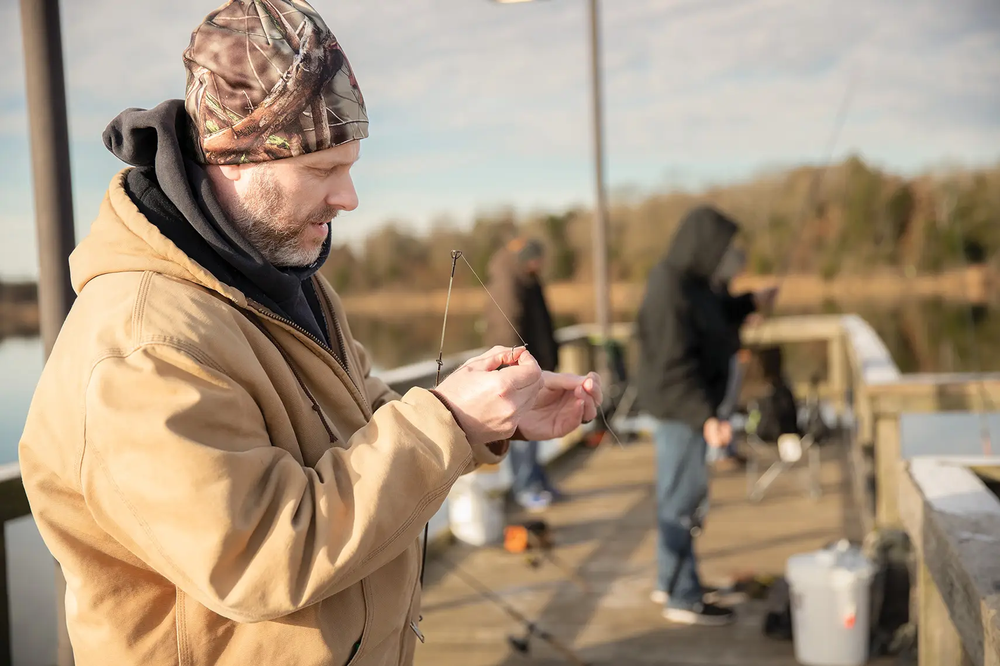 Fishermen on Purtis Creek baiting their lures on the fishing pier