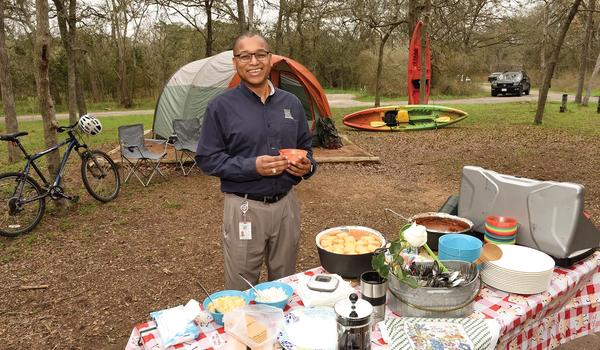 Rodney Frankling at a picnic table covered in food at a campsite
