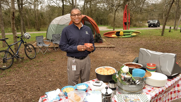 Rodney Frankling at a picnic table covered in food at a campsite