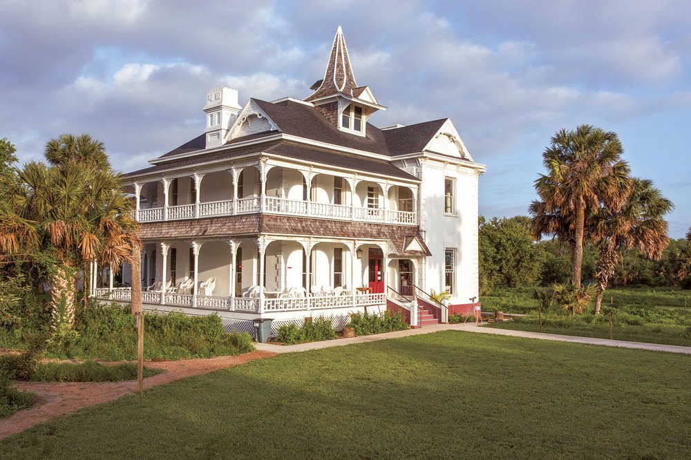 Two story home with wrap around porches and Sabal Palms