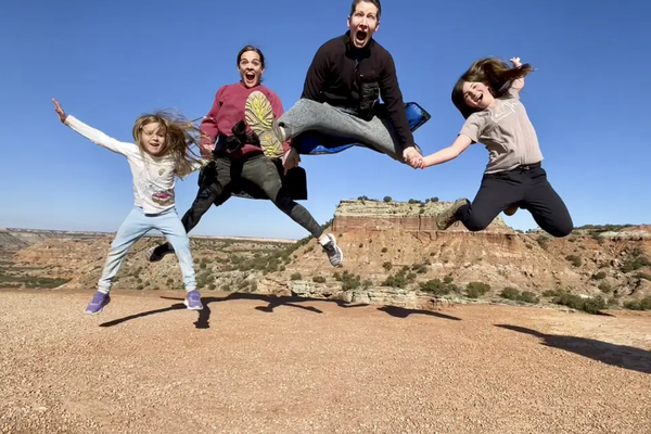 Sam Holm and Family in Palo Duro Canyon State Park jumping as a family holding hands
