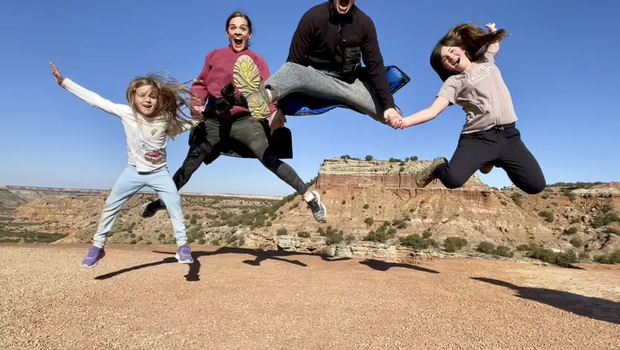 Sam Holm and Family in Palo Duro Canyon State Park jumping as a family holding hands