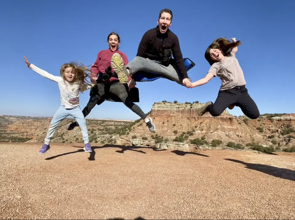 Sam Holm and Family in Palo Duro Canyon State Park jumping as a family holding hands