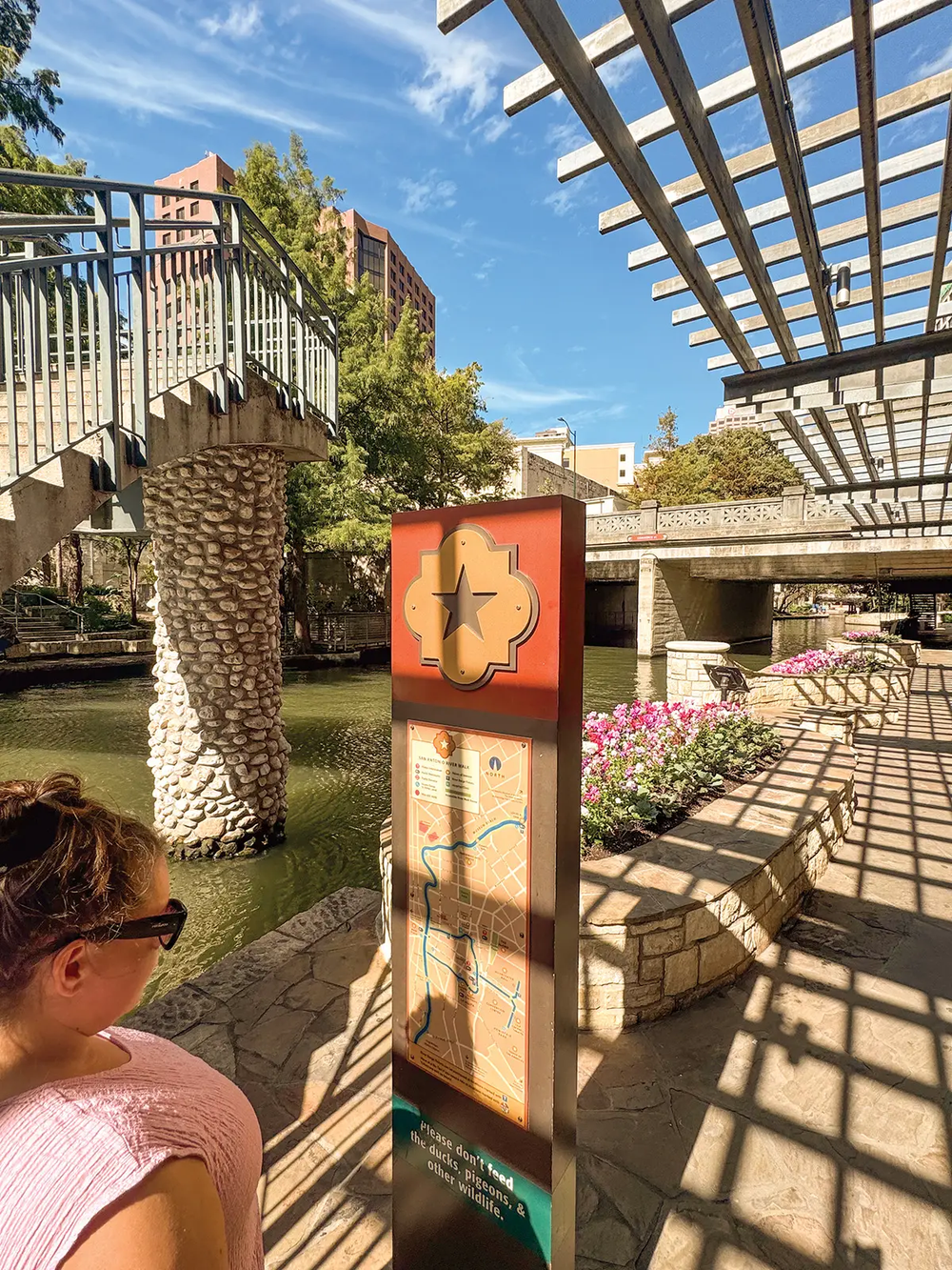 San Antonio River Walk with a woman looking at a map of the river walk