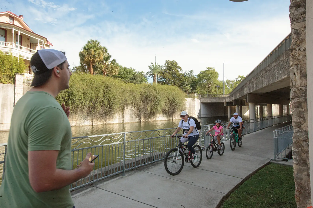 San Antonio River Walk people riding bikes and a person walking