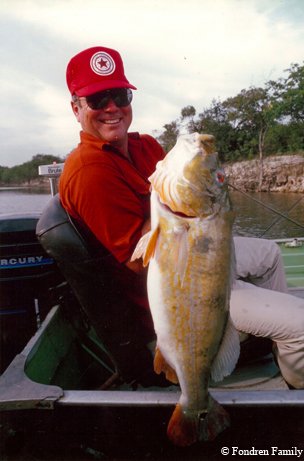 Walter Fondren lll in red showing a fish to the camera