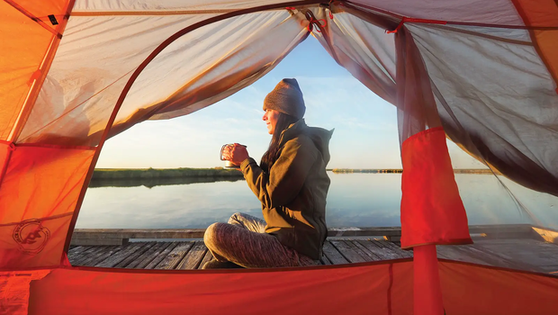 Sea Rim State Park woman in a tent on a floating platform drinking a beverage