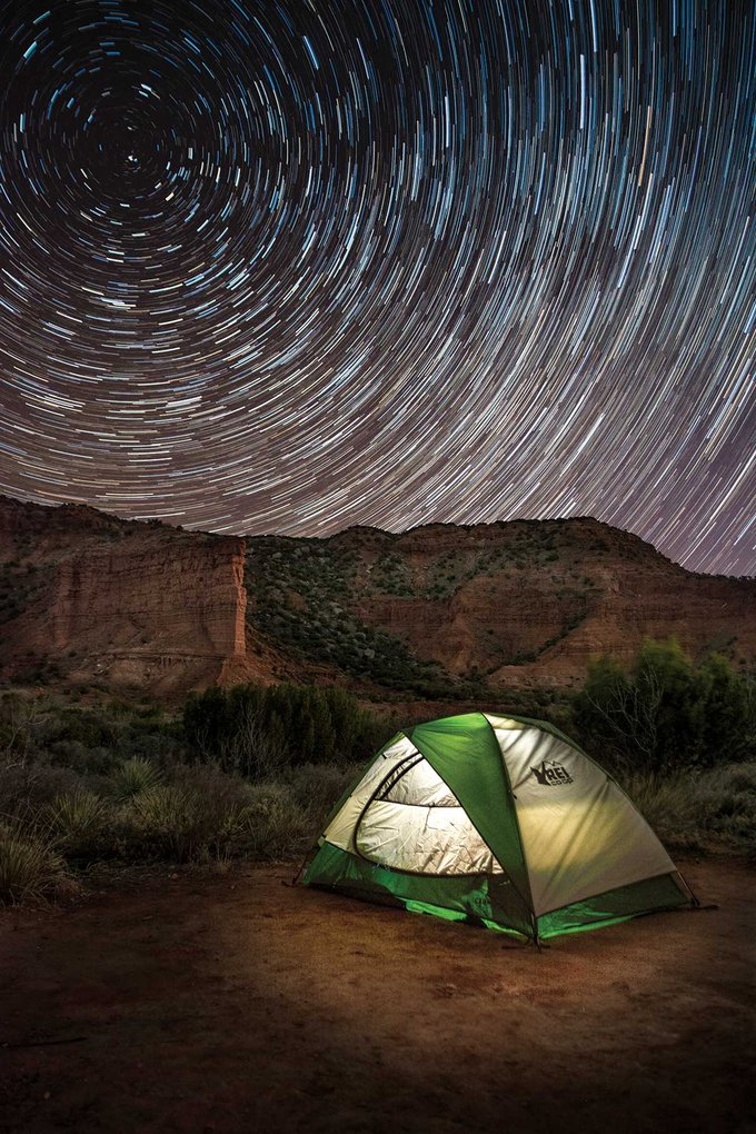 Tent in a canyon with a timelapsed night sky.