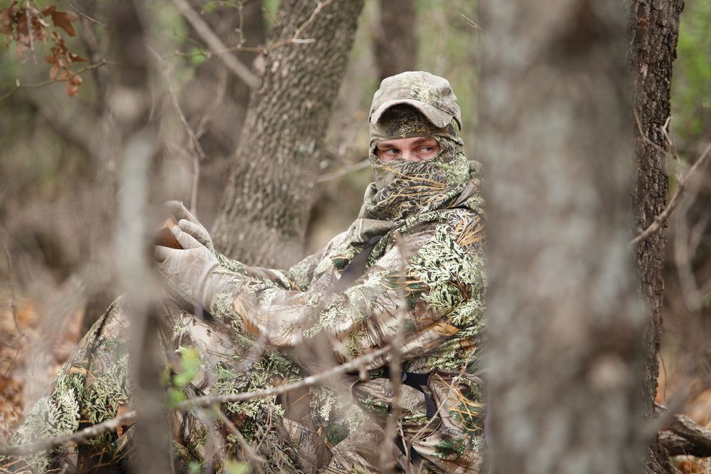 Turkey hunter in camo with a turkey call.