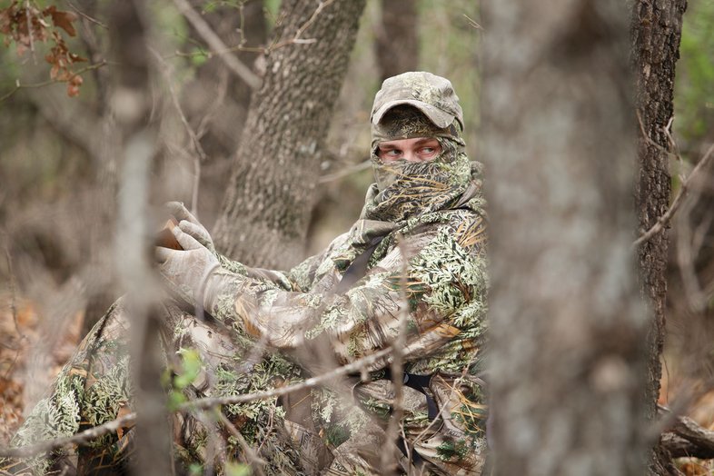 Turkey hunter in camo with a turkey call.