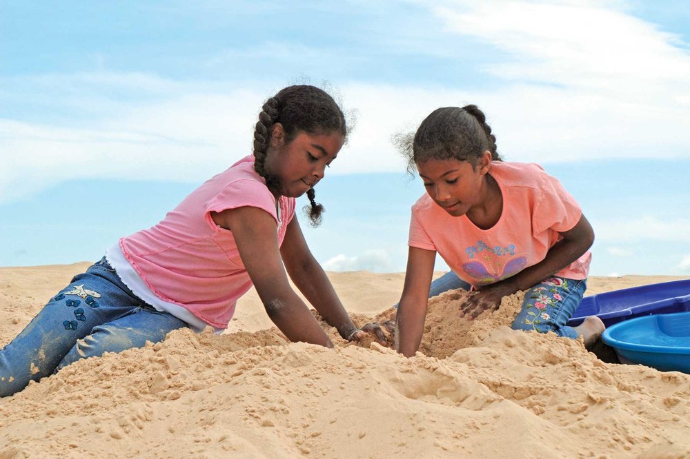 Two girls playing in the sand