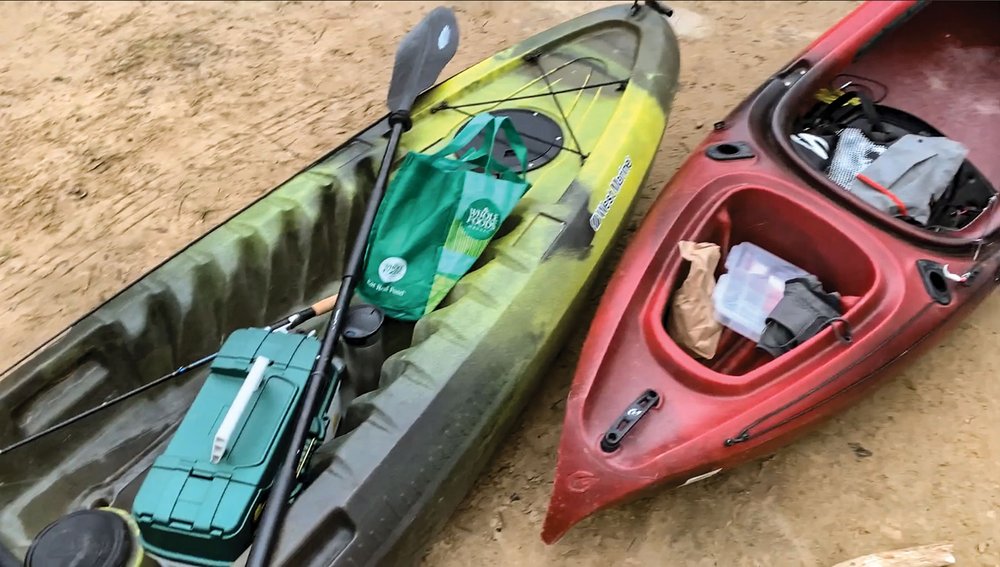 Two kayaks o the shore with supplies