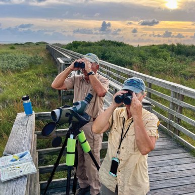 Two people looking through binoclars on an overlook at Port Oconnor