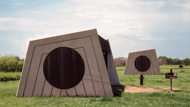 Picnic structure with concrete walls with a circular cutout.