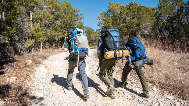three people backpacking through the trails of pedernales falls
