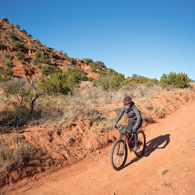 Biker rides down a dirt trailway
