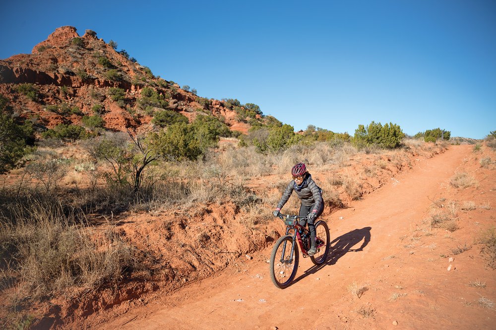 Biker rides down a dirt trailway