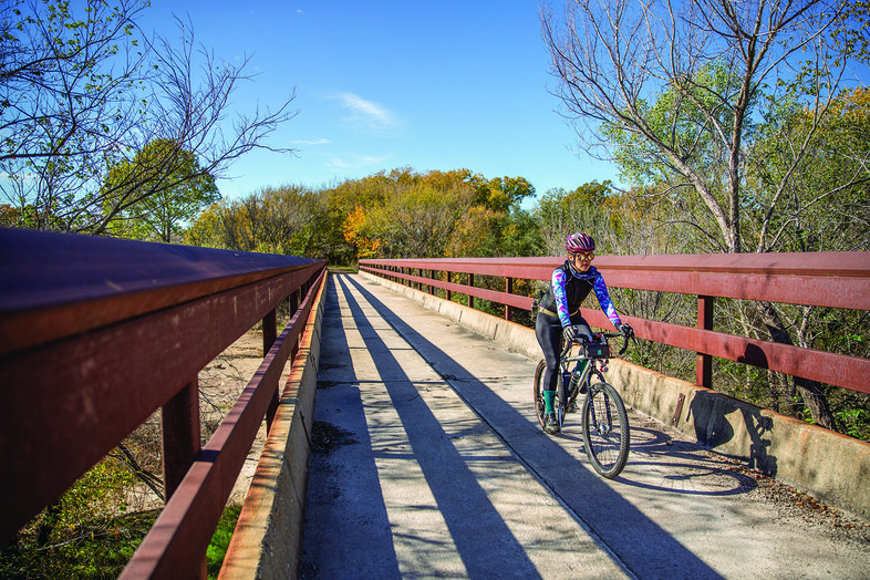 A biker rides on Lake Mineral Wells trailway bridge
