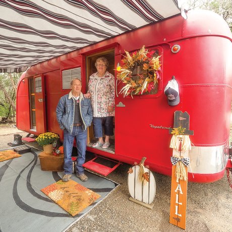 Two people next to a red trailer