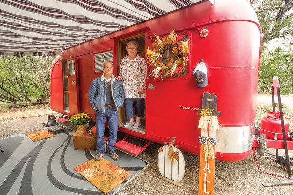 Two people next to a red trailer