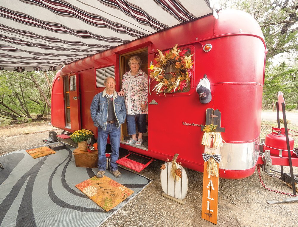 Two people next to a red trailer