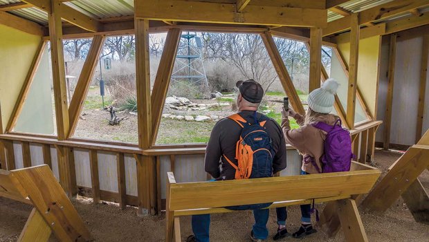 two people with backpacks on sitting in the davis mountains blind taking a picture