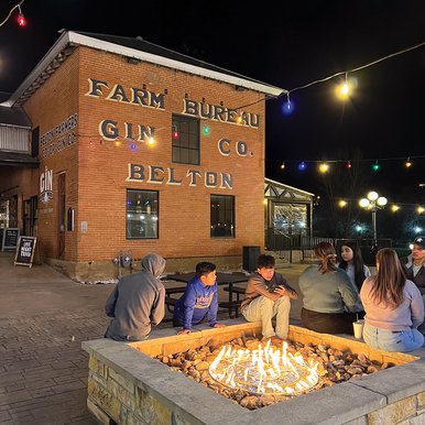 People around a stone fire pit at night
