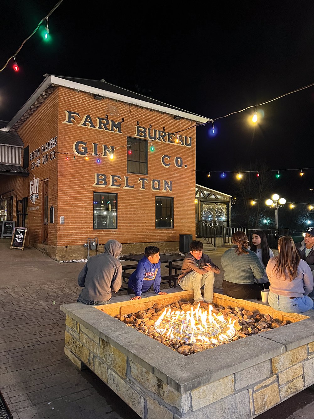 People around a stone fire pit at night