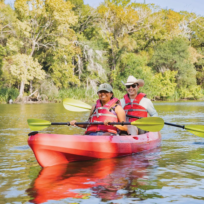 Two people in a red kayak on a river