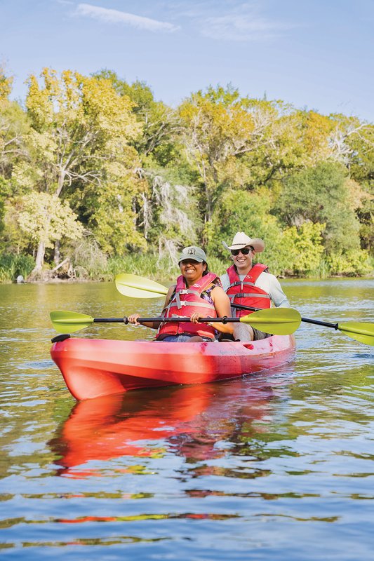 Two people in a red kayak on a river