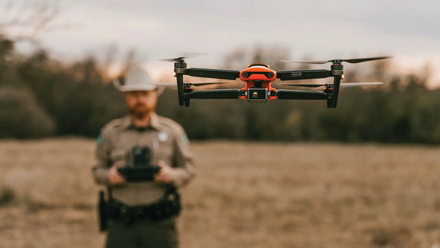 game warden using a drone flying it about heads height.