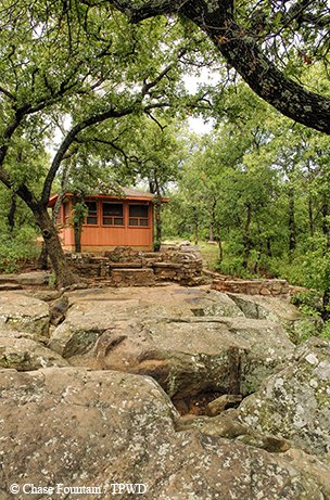 rocky terrain with a wood cabin in the woods at lake mineral wells