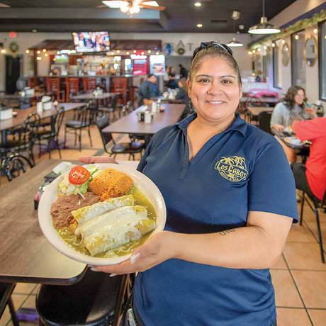 A woman holds a plate of food at Los Cabos