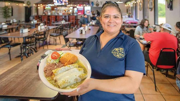 A woman holds a plate of food at Los Cabos