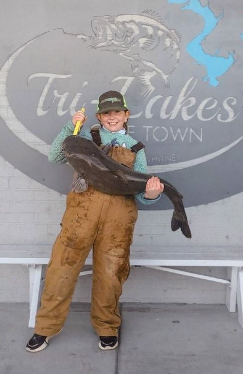 Maggy Sojourner holds a blue catfish she caught